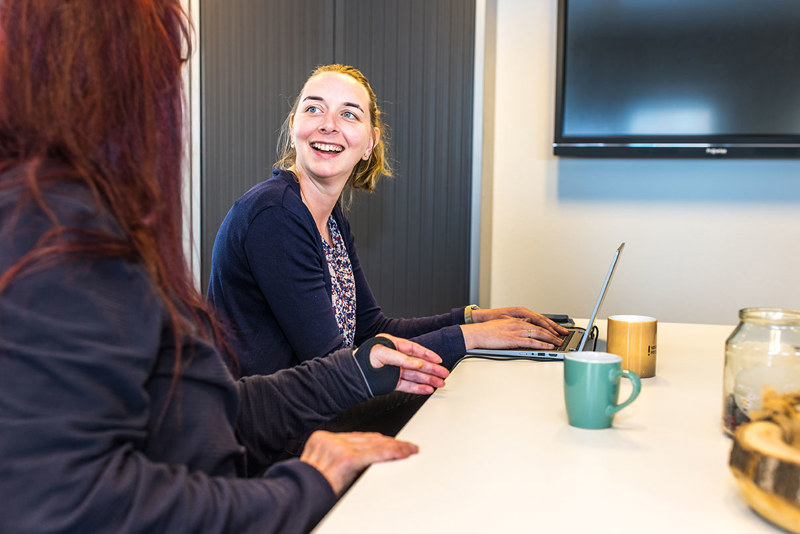Arts Lacht Naar Collega En Werkt Achter Laptop