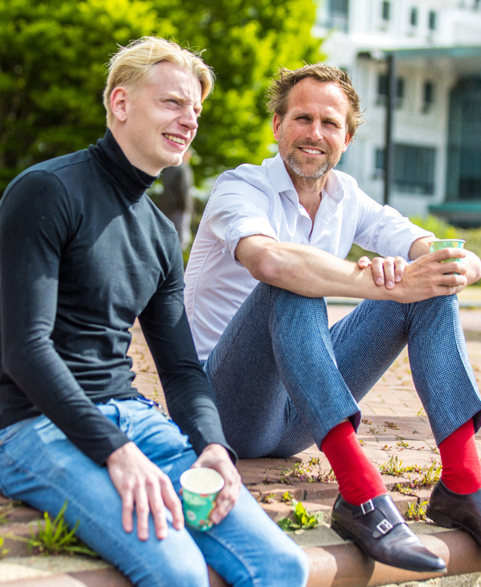 twee collega's zitten buiten in de zon 